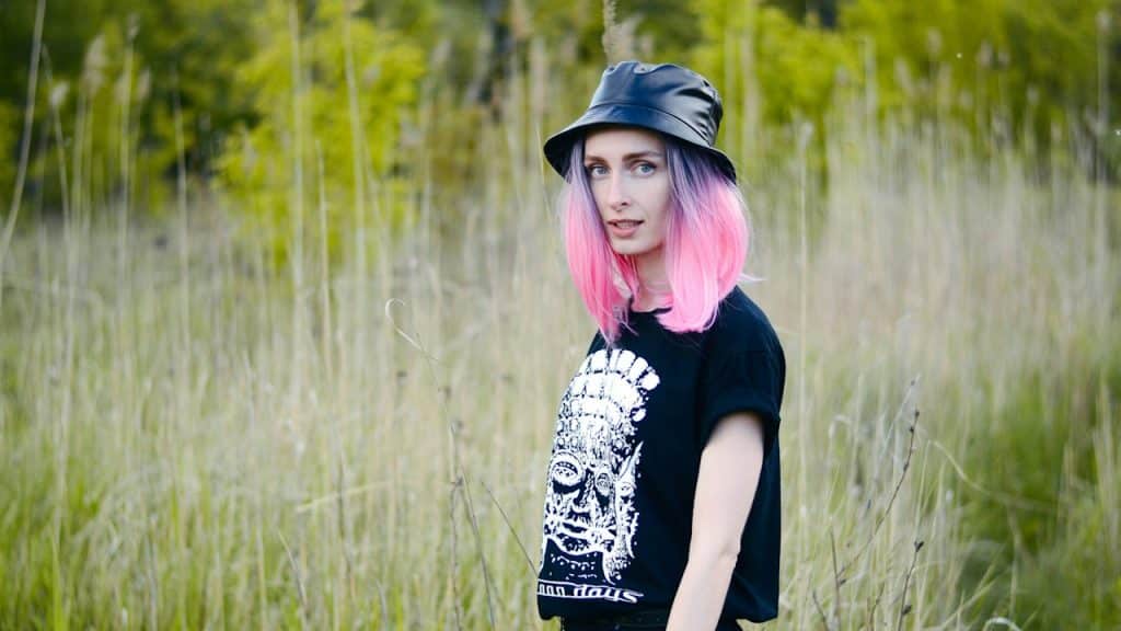 A beautiful woman standing in tall grass.