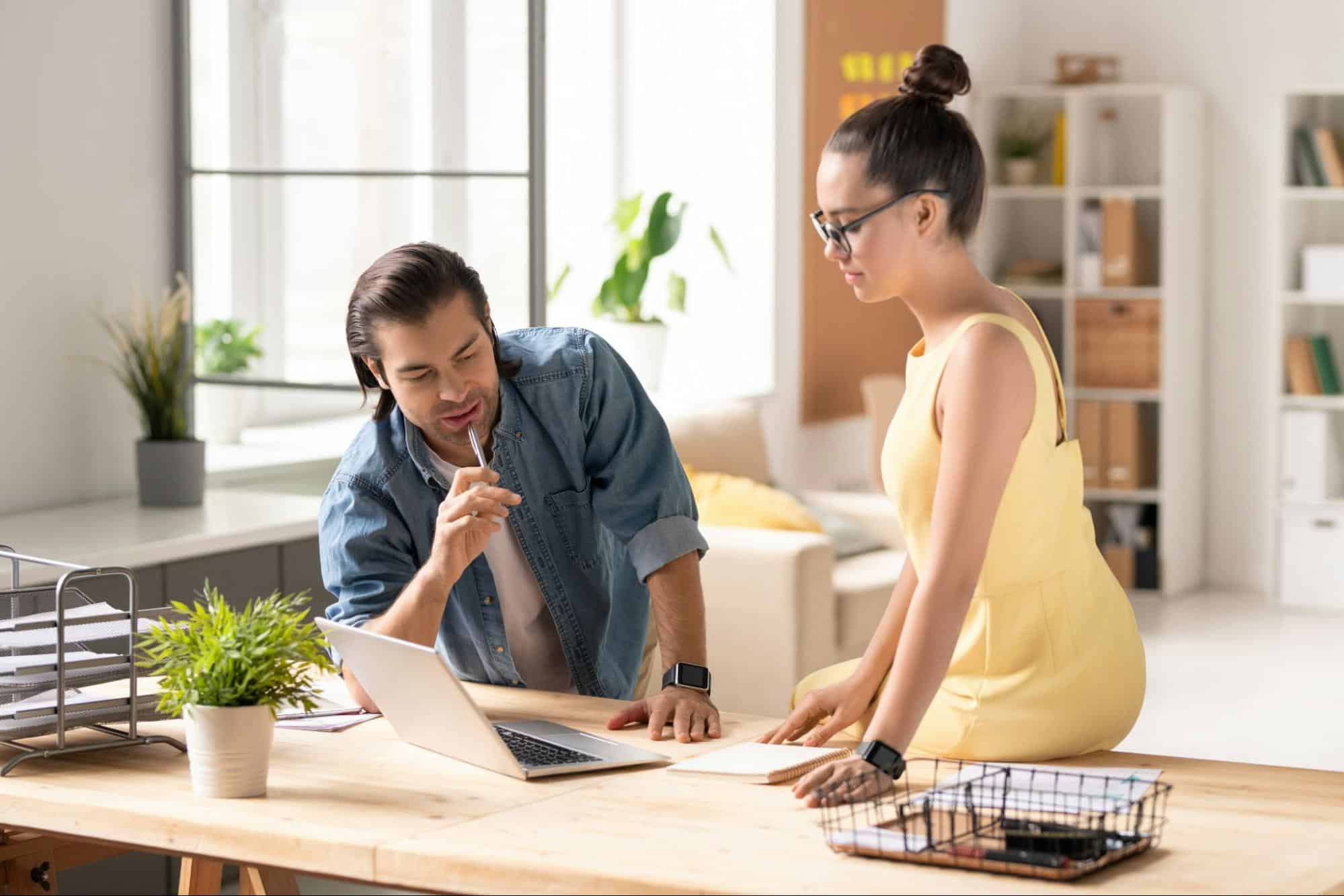 A man and woman looking at the laptop