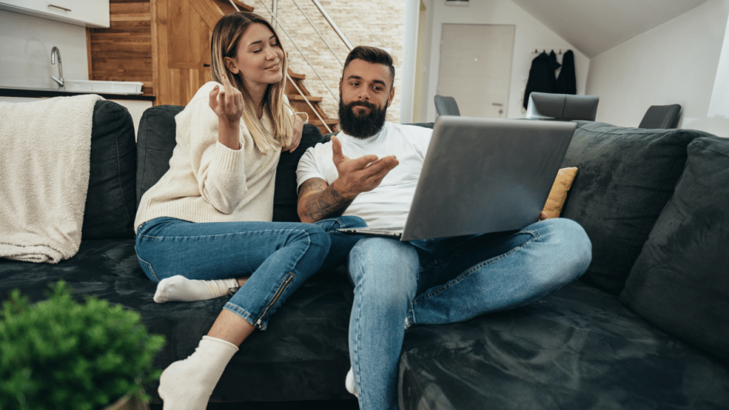 A couple talking while looking at a laptop