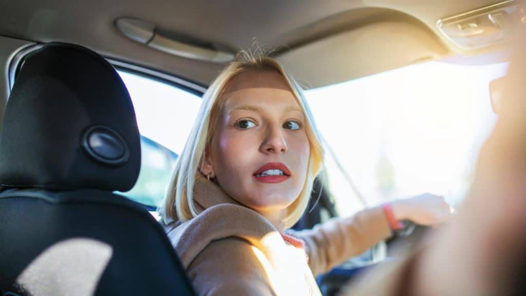 A person driving a car and looking back.