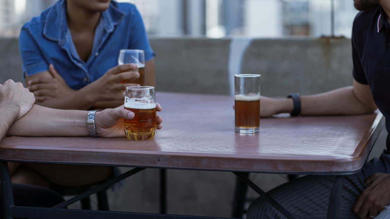 A group of people sitting at a table with glasses of beer.