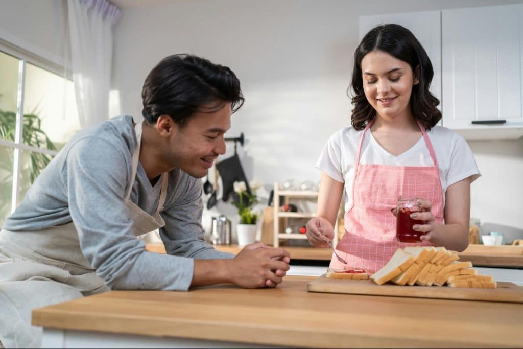 A man approach a woman in the kitchen