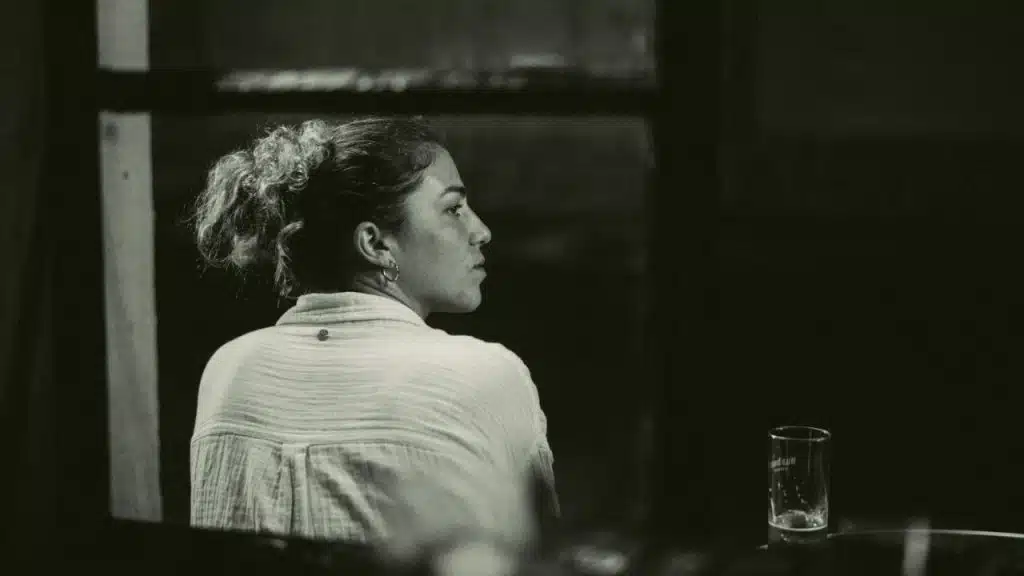 A woman with hair in a bun looks away in a black and white profile shot.