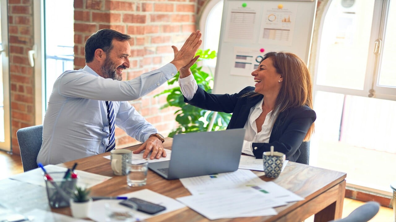 Colleagues high fiving in the office 