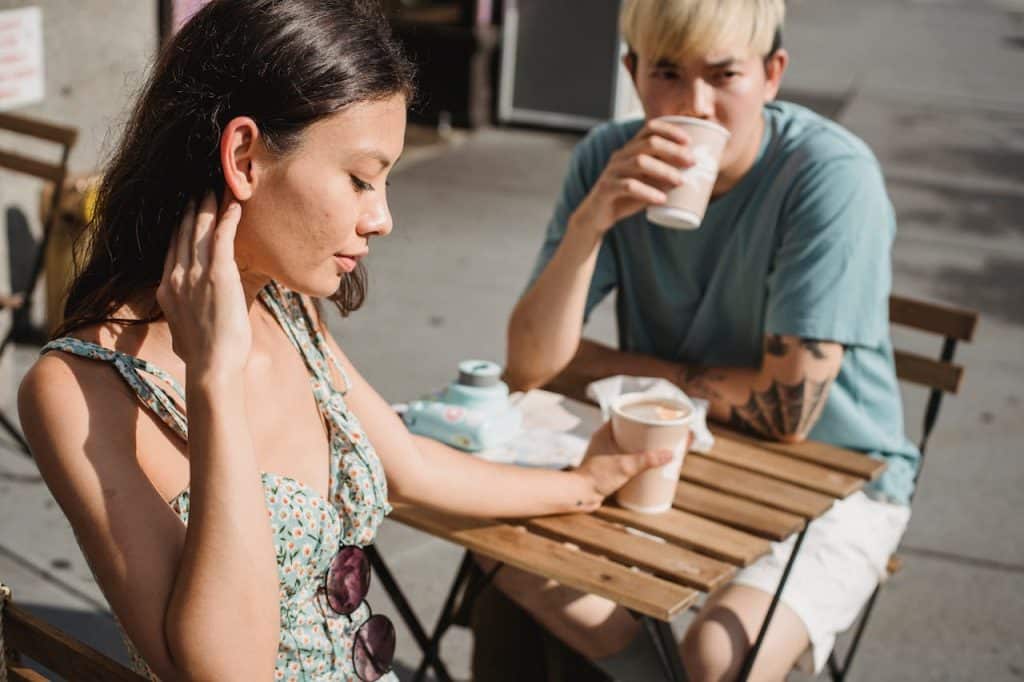 A couple drinking coffee in a street café.
