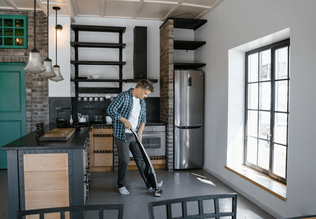 A man vacuuming the floor