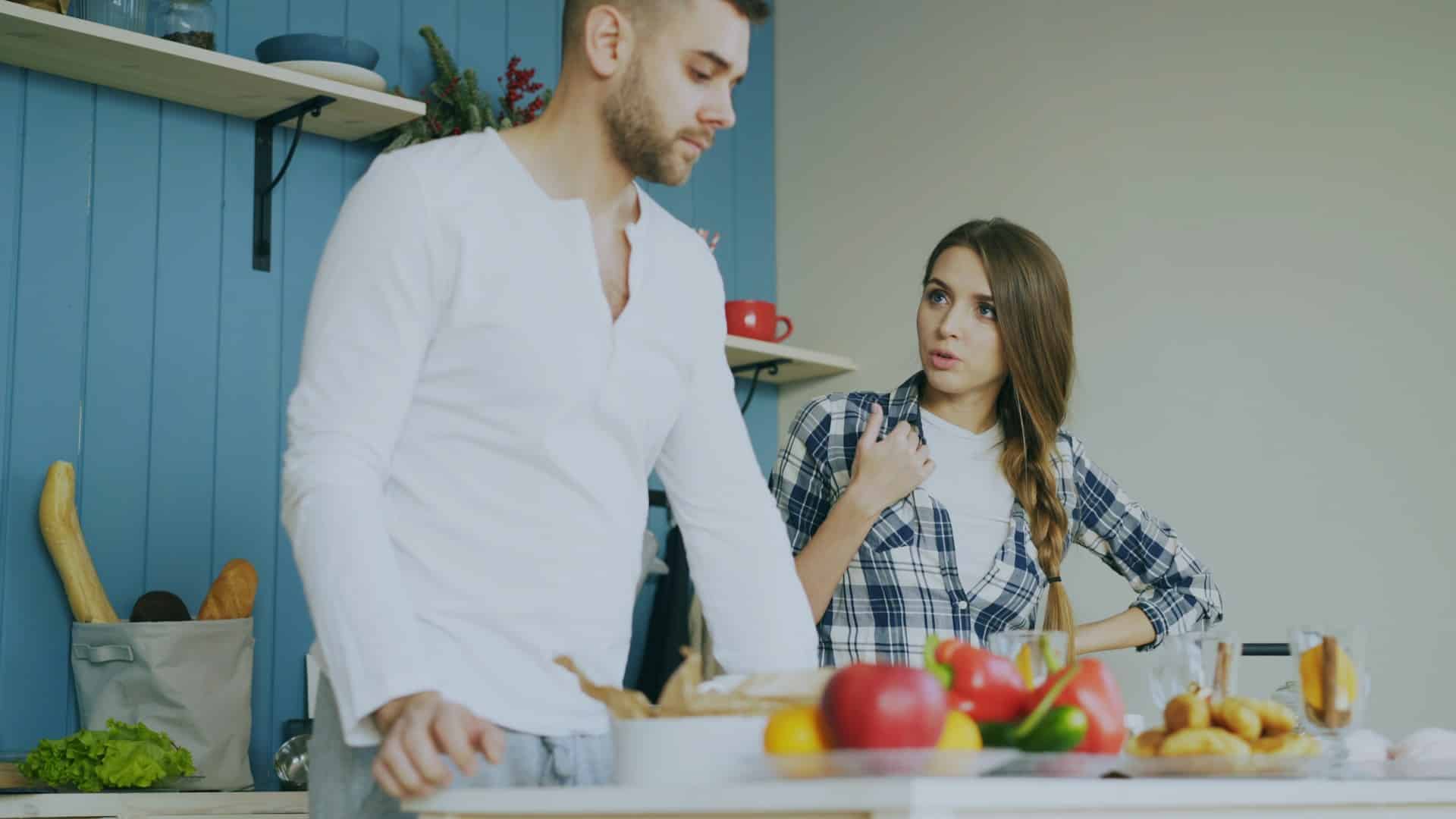 A couple arguing in the kitchen.