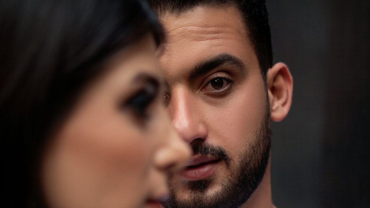 A bearded man looking at a woman.