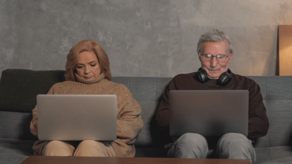 A mature couple busy with their laptops
