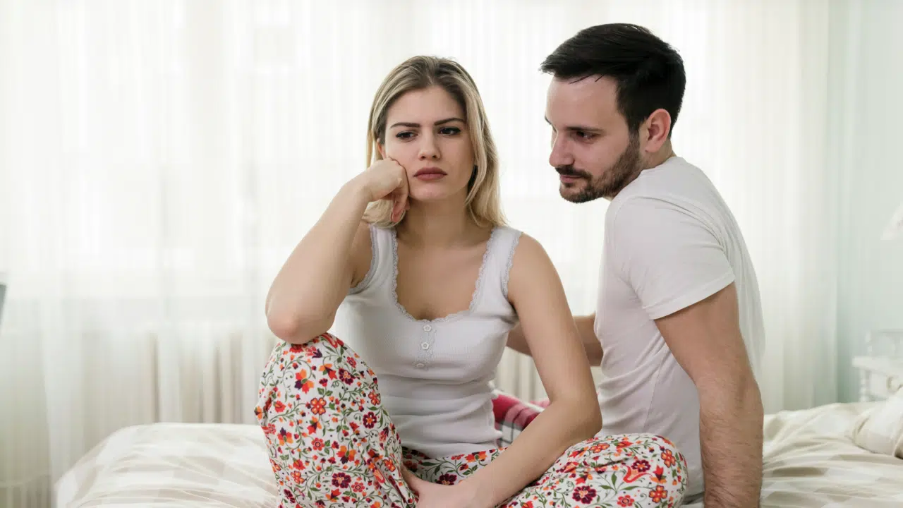 A couple looking sad in the bedroom