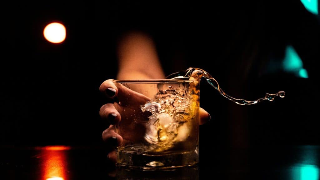 A man holding a glass of whiskey