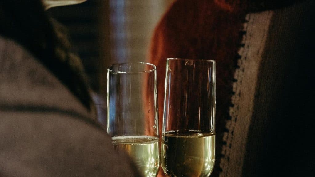 A close-up of two people holding champagne glasses.