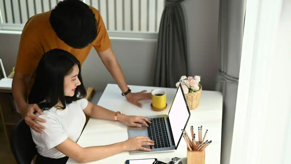 Man standing over and leaning down toward a woman with a somber expression.