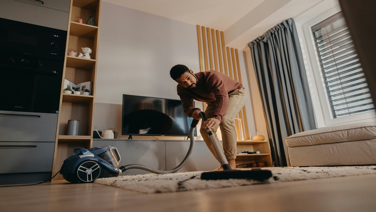 A man vacuuming his living room
