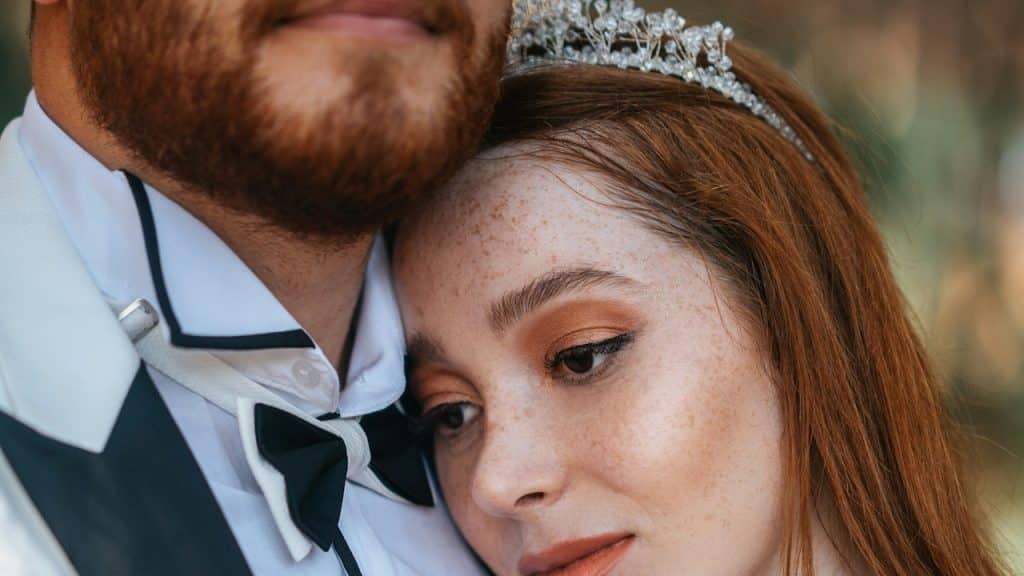 A woman putting her head on her boyfriend's shoulder.