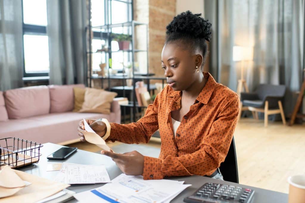 A woman putting a filled form into an envelope.