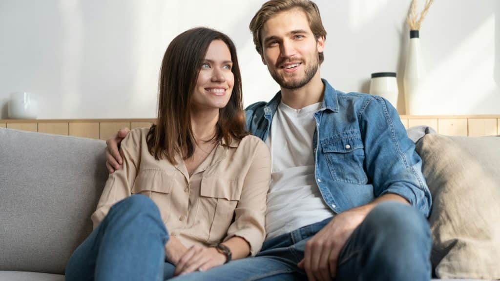 A man and a woman sitting on a couch together.