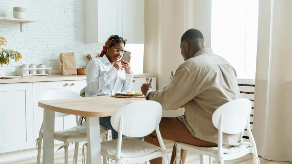 A couple having breakfast at a kitchen table.