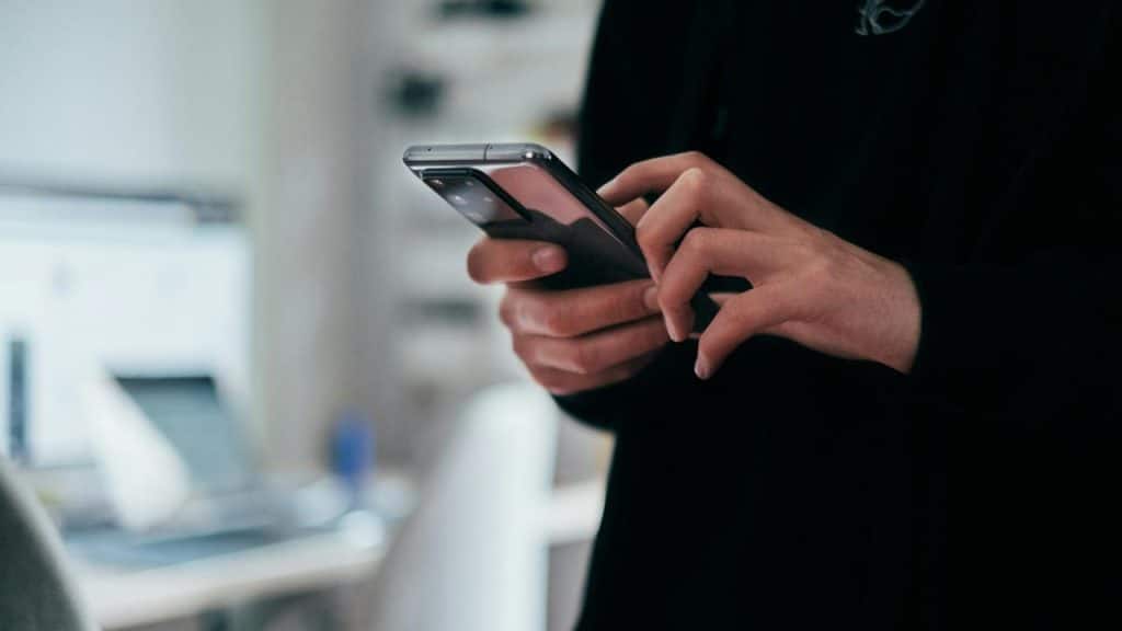 A person typing on a smartphone.