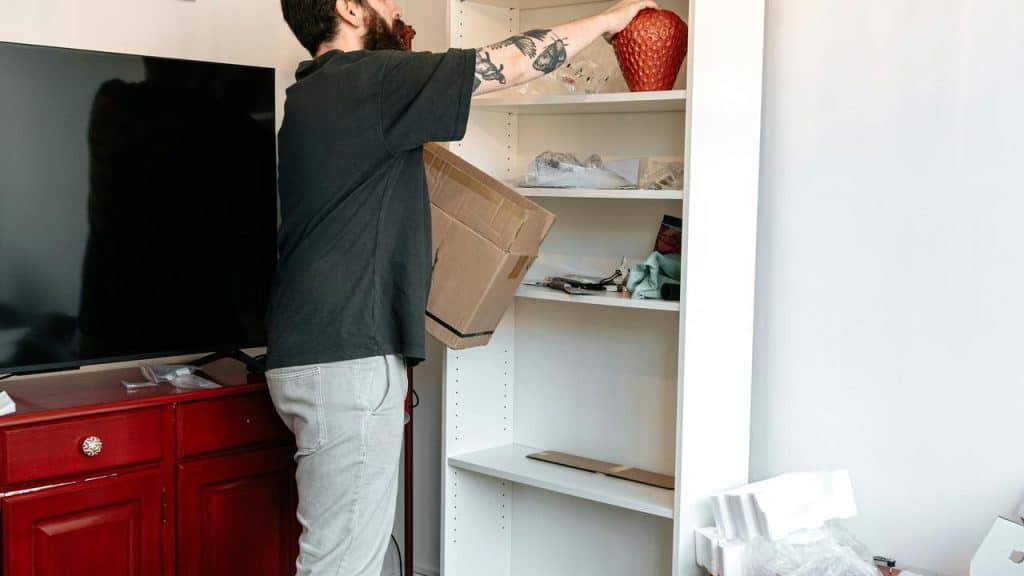 A person unpacking items onto a shelf.