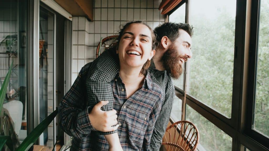 A man and a woman holding each other and laughing.