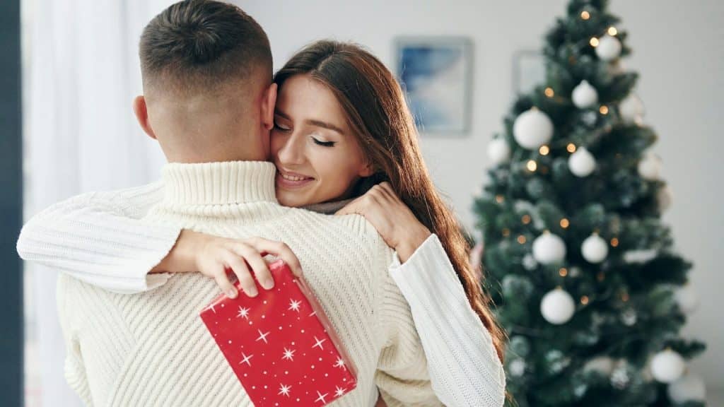 A woman hugging a man after receiving a gift from him.