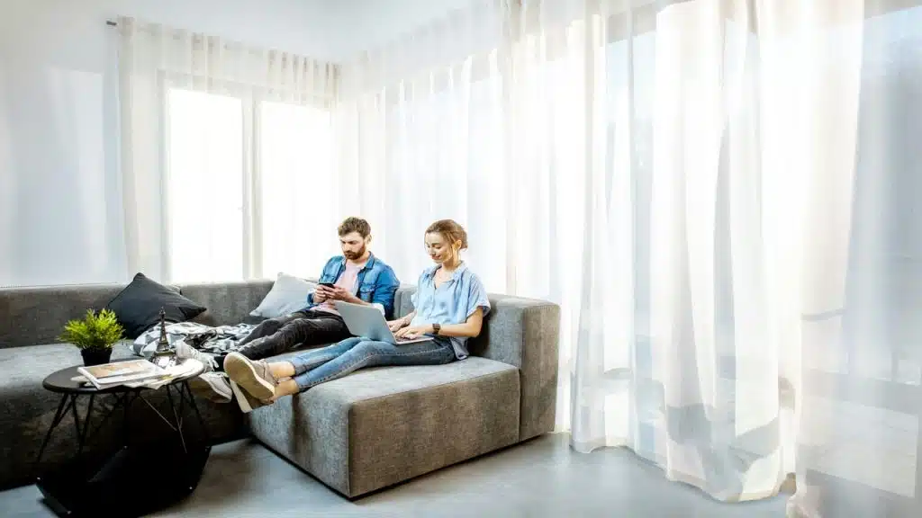 A couple using their devices at home