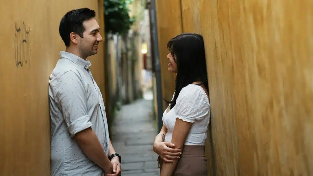 A couple standing in a narrow alleyway.