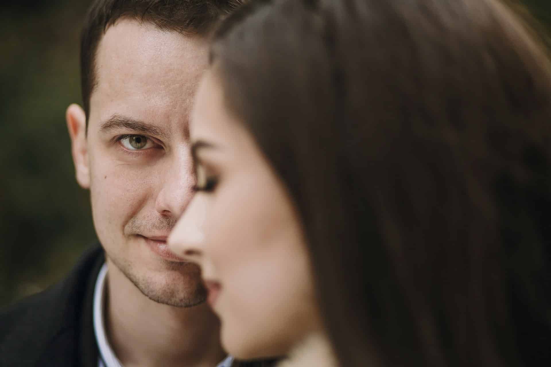 A man smiling while a woman smiles in the foreground.