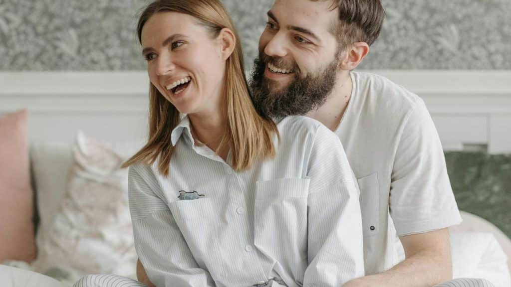 A couple sitting close together and laughing.