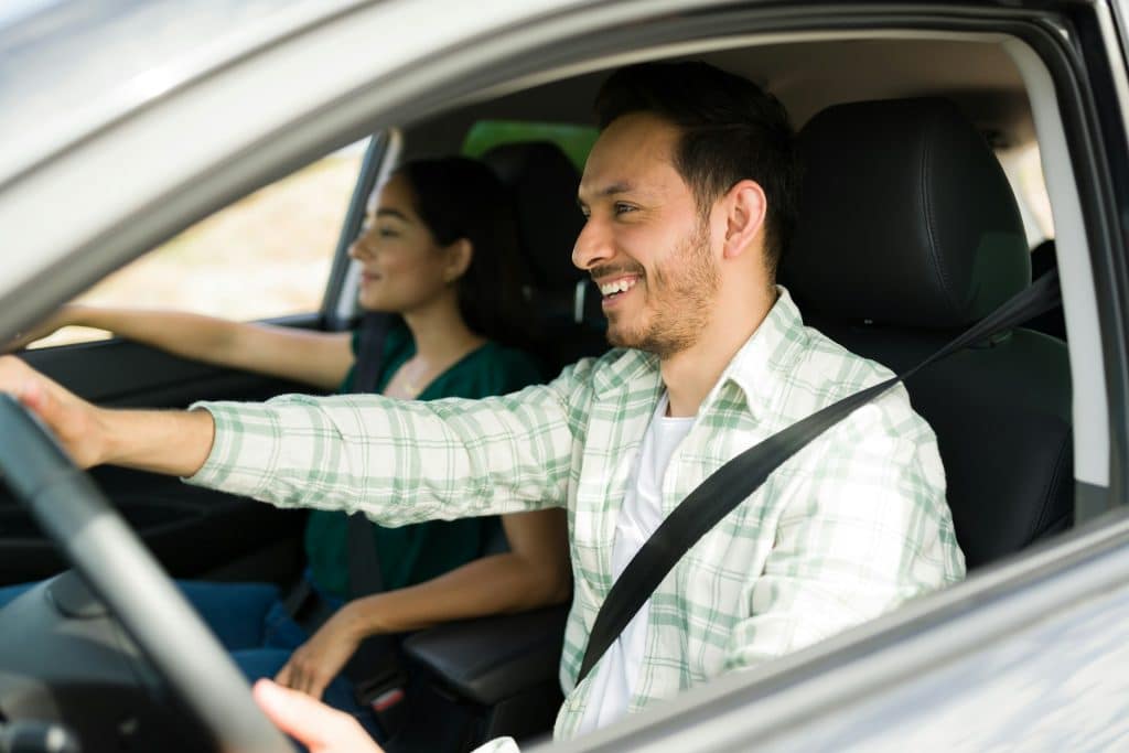 A man driving with his girlfriend.