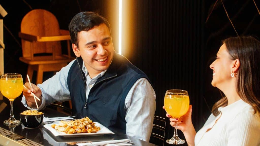 A couple enjoying drinks and food at a restaurant.