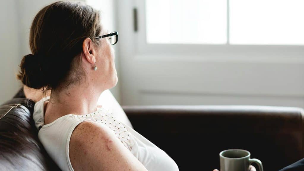 A person sitting on a couch holding a mug.