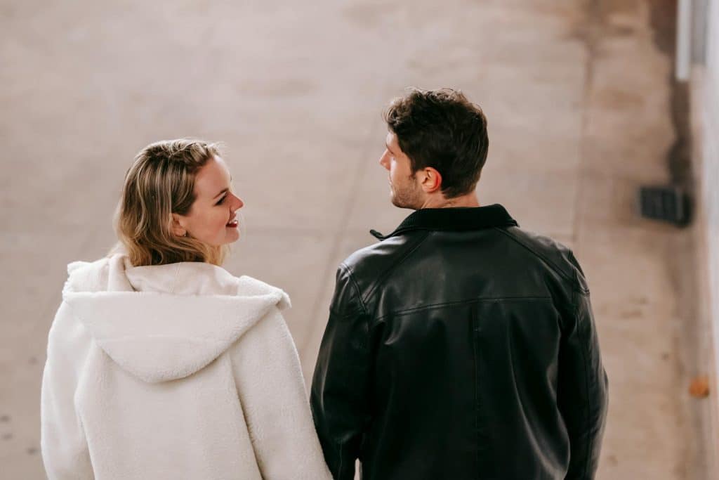 A couple talking while walking in the city.