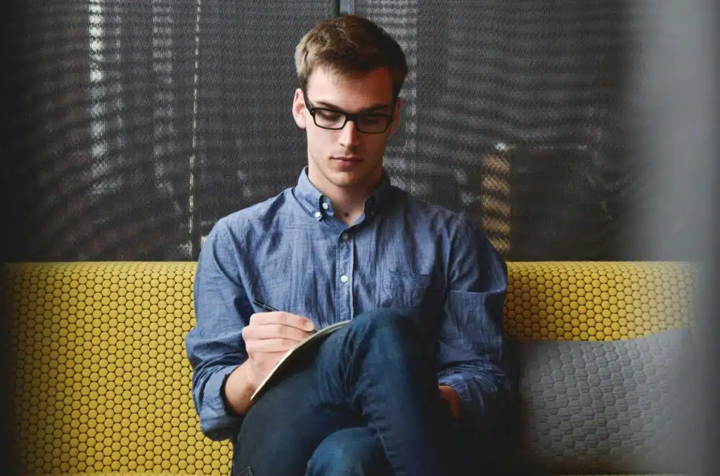 A man sitting while writing