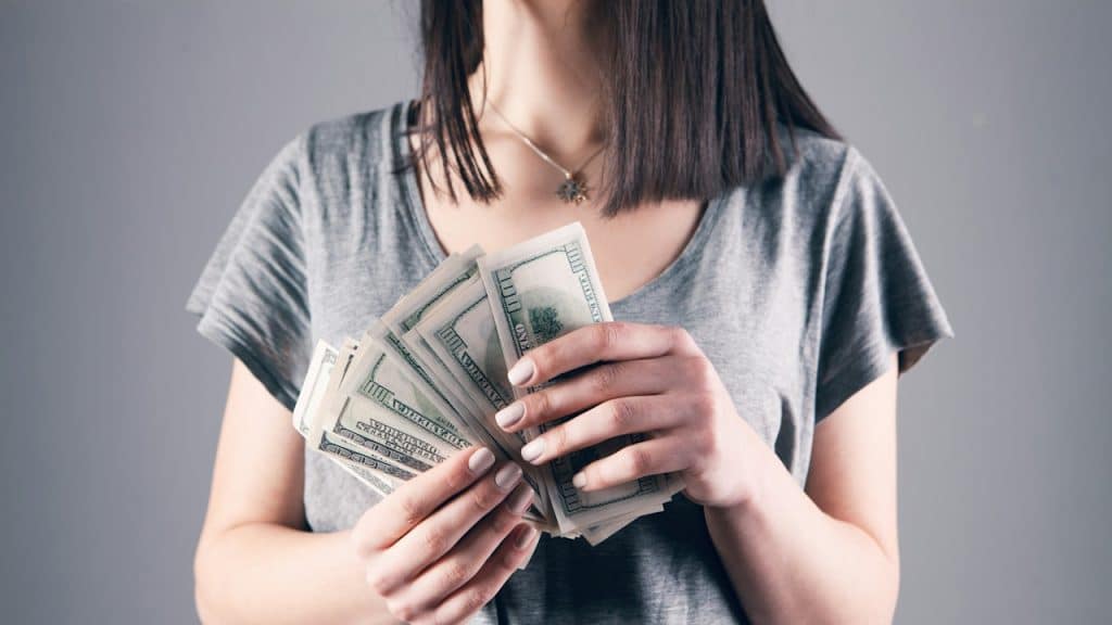 A woman holding dollar bills in her hands.