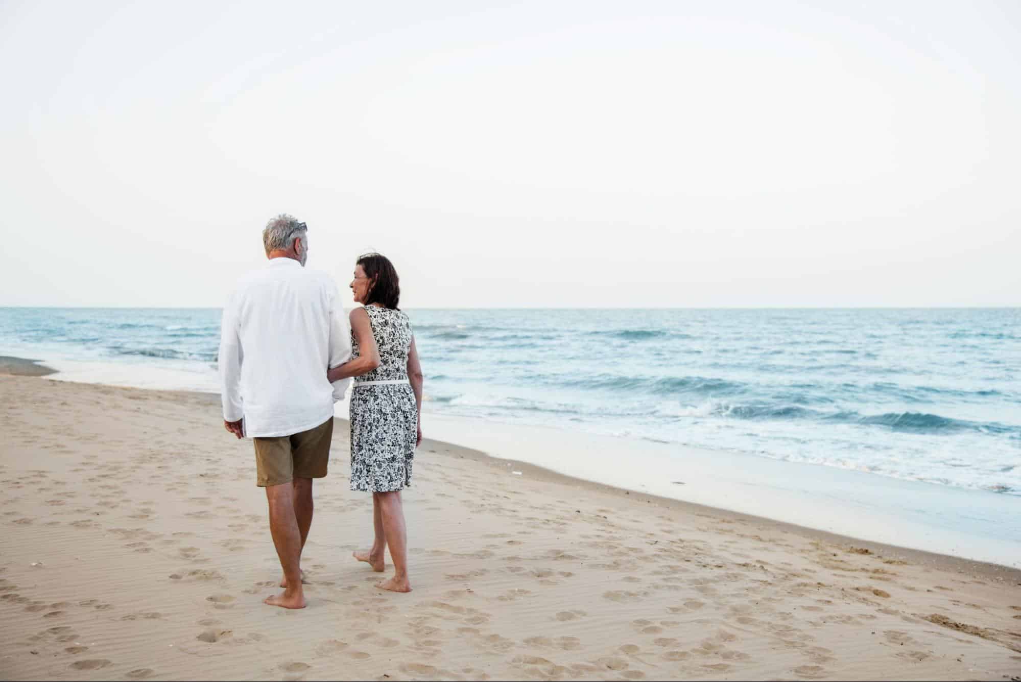 A man and woman walking at the sand