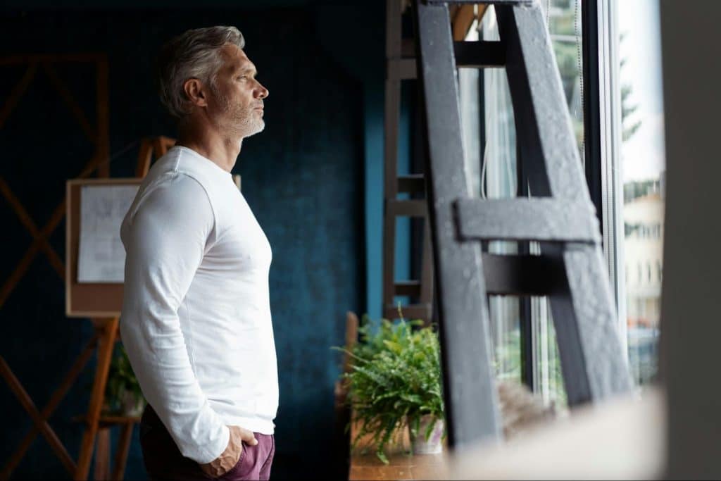 A man standing beside the window