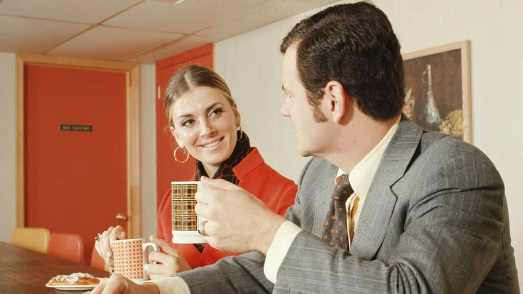 A couple in a coffee shop having breakfast, Danish pastries, and coffee.