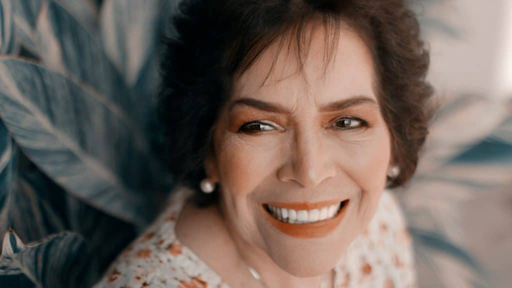 A happy old woman looking in a camera.