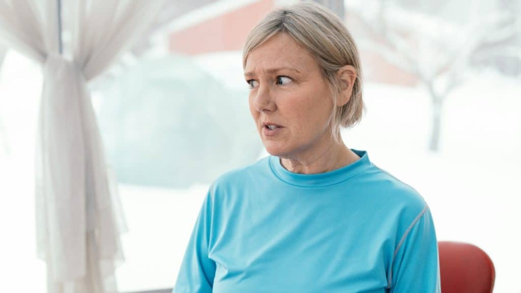 A depressed woman sitting at a table.