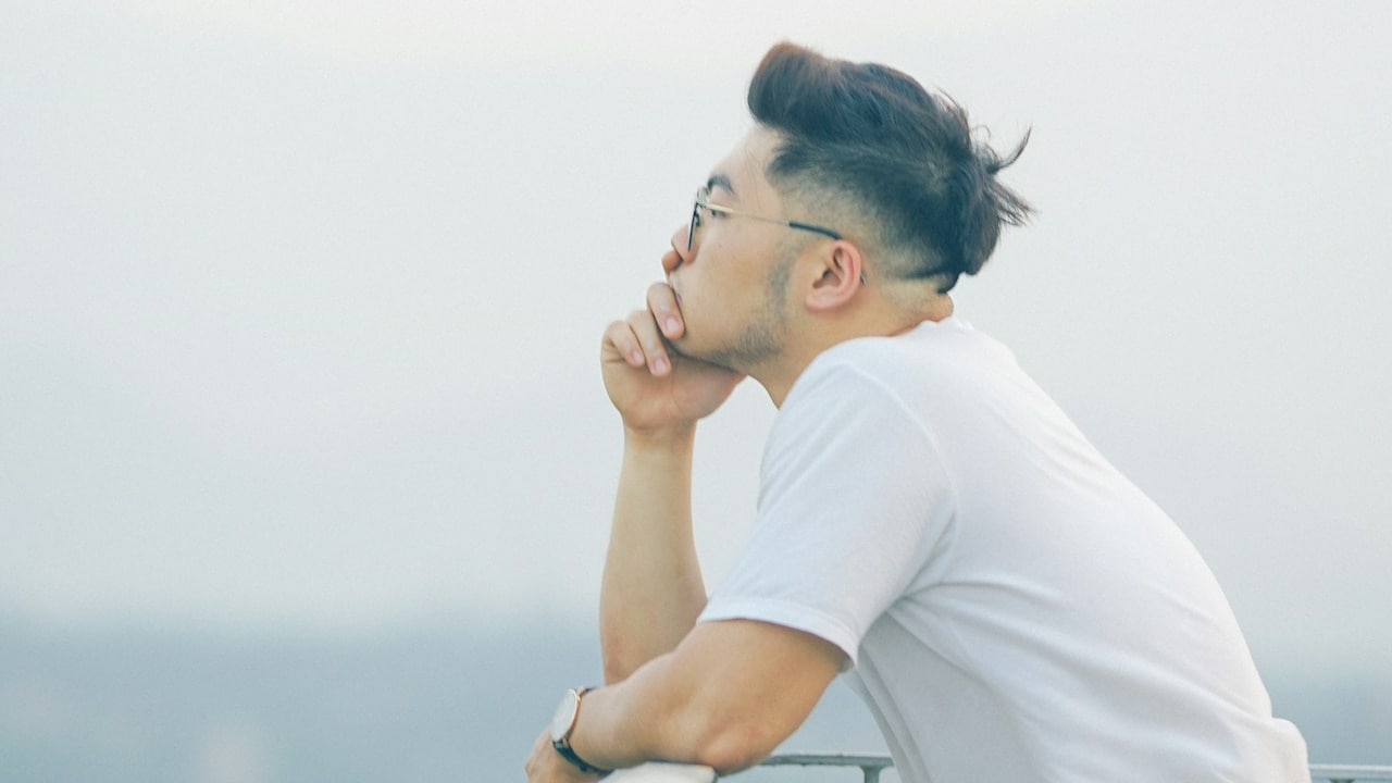 A man wearing glasses gazing into the distance.