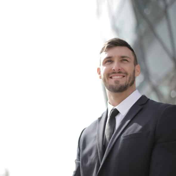 A man in black suit smiling.