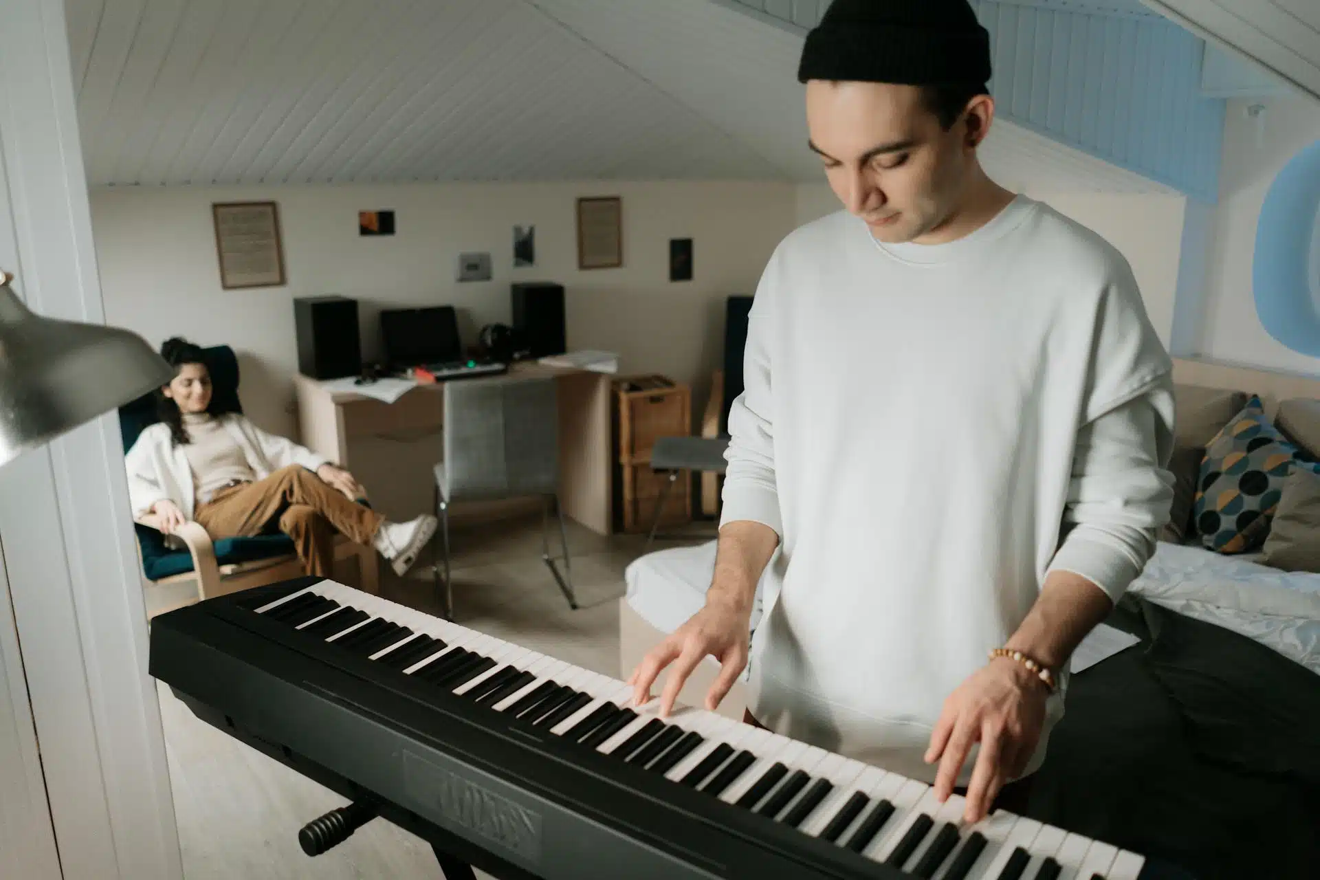 A woman watching the man playing piano.