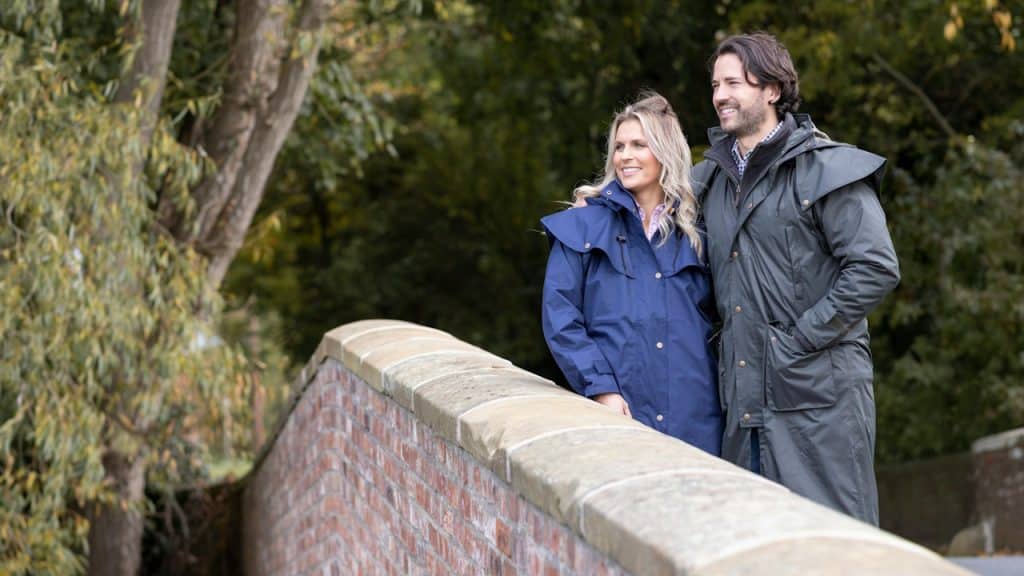 A man and a woman standing on a bridge.