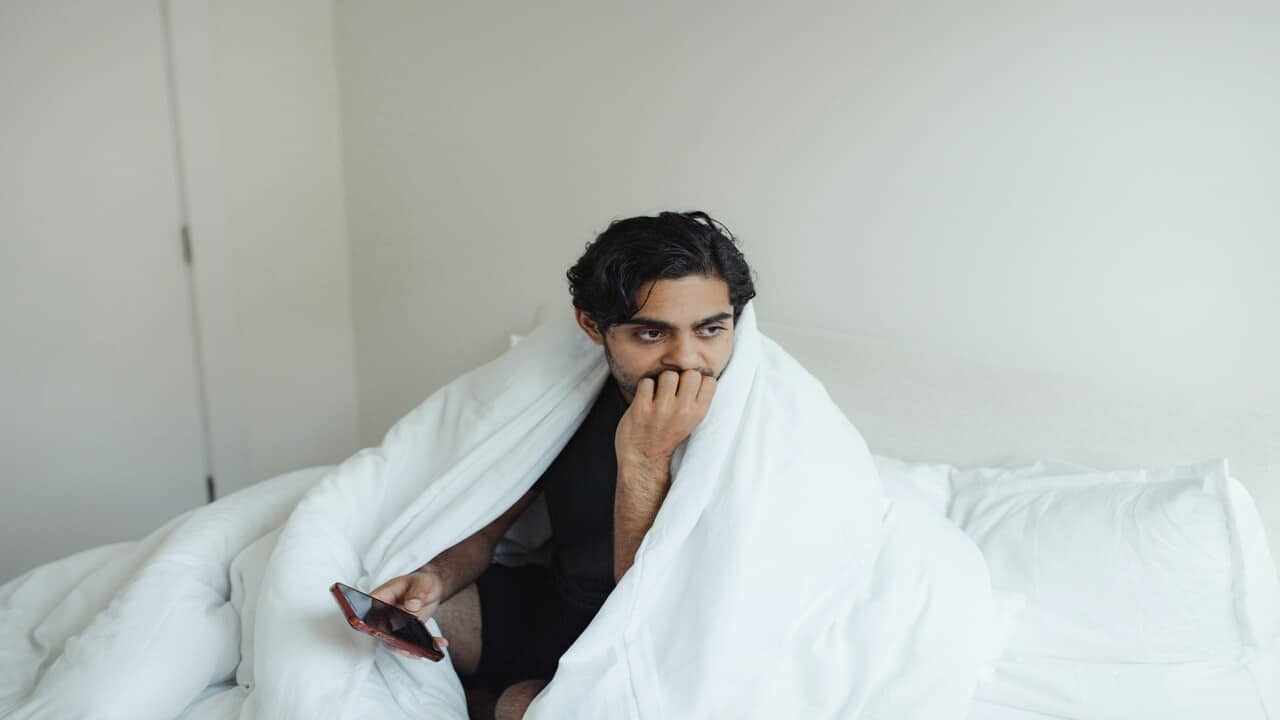 A man looking sad in the bedroom