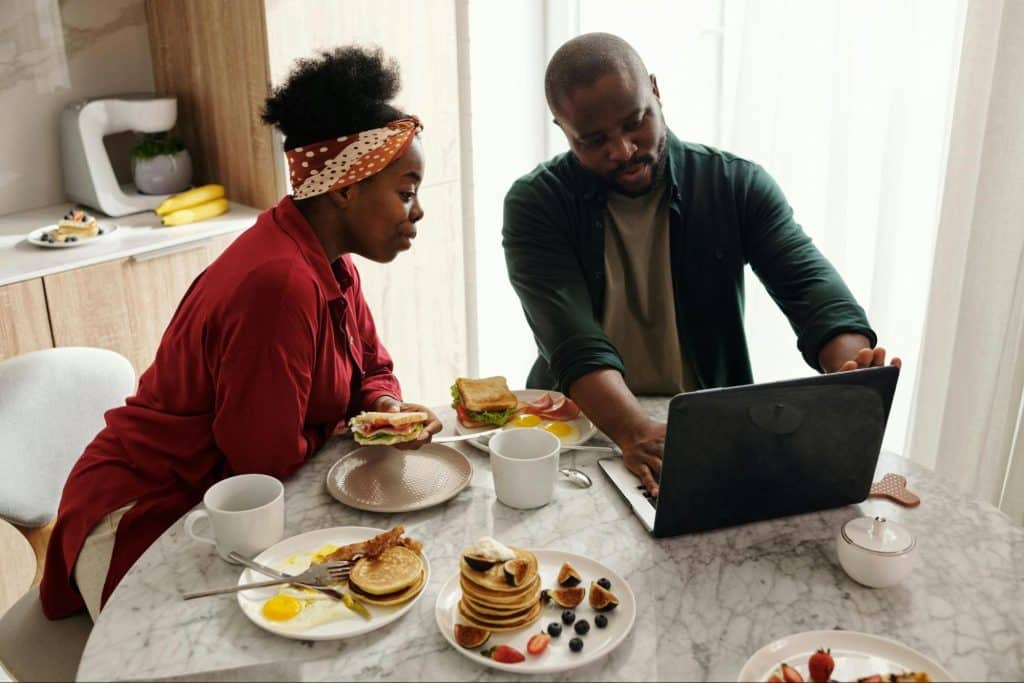 A man and woman looking at the laptop