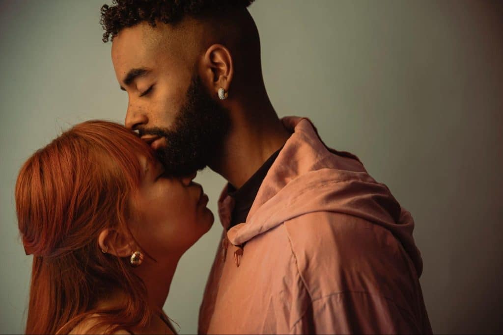 A man kissing a woman’s forehead