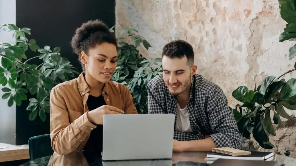 A woman and a man looking at a laptop together.