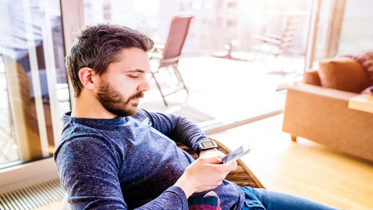 A man looking sad while looking at his phone